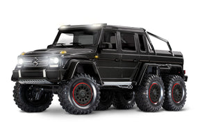 Traxxas TRX-6 Mercedes-Benz G 63 6x6 RC truck front left view, black detailed scale model with realistic features.