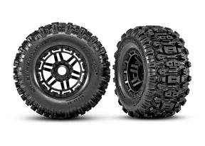 Pair of Traxxas Maxx 2.8-inch black wheels with Sledgehammer tires, showing the rugged off-road tread pattern and sturdy design.