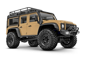 Traxxas TRX-4M Land Rover Defender remote control vehicle front three-quarter view in tan color.