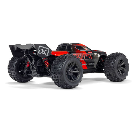 ARRMA 1/16 Mini Kraton 3S RC truck in orange with large tires and detailed chassis, shown from a side angle.