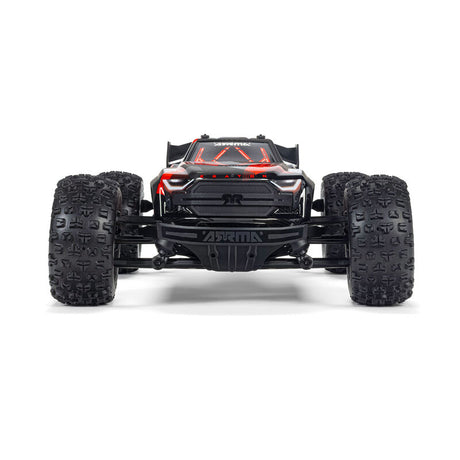 ARRMA 1/16 Mini Kraton 3s remote control car on a track with rugged tires and detailed orange and black body.