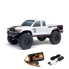 Axial 1/24 SCX24 Base Camp 4x4 RTR brushed rock crawler on rugged terrain with detailed chassis and tires.