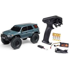 Red and black Axial 1/24 scale Toyota 4Runner 4x4 RC rock crawler on rugged terrain, ready for off-road adventure.