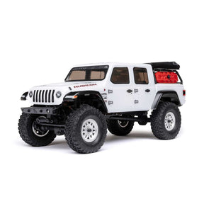 Axial 1/24 SCX24 Jeep JT Gladiator 4X4 brushed rock crawler on rugged terrain with detailed exterior and off-road features.